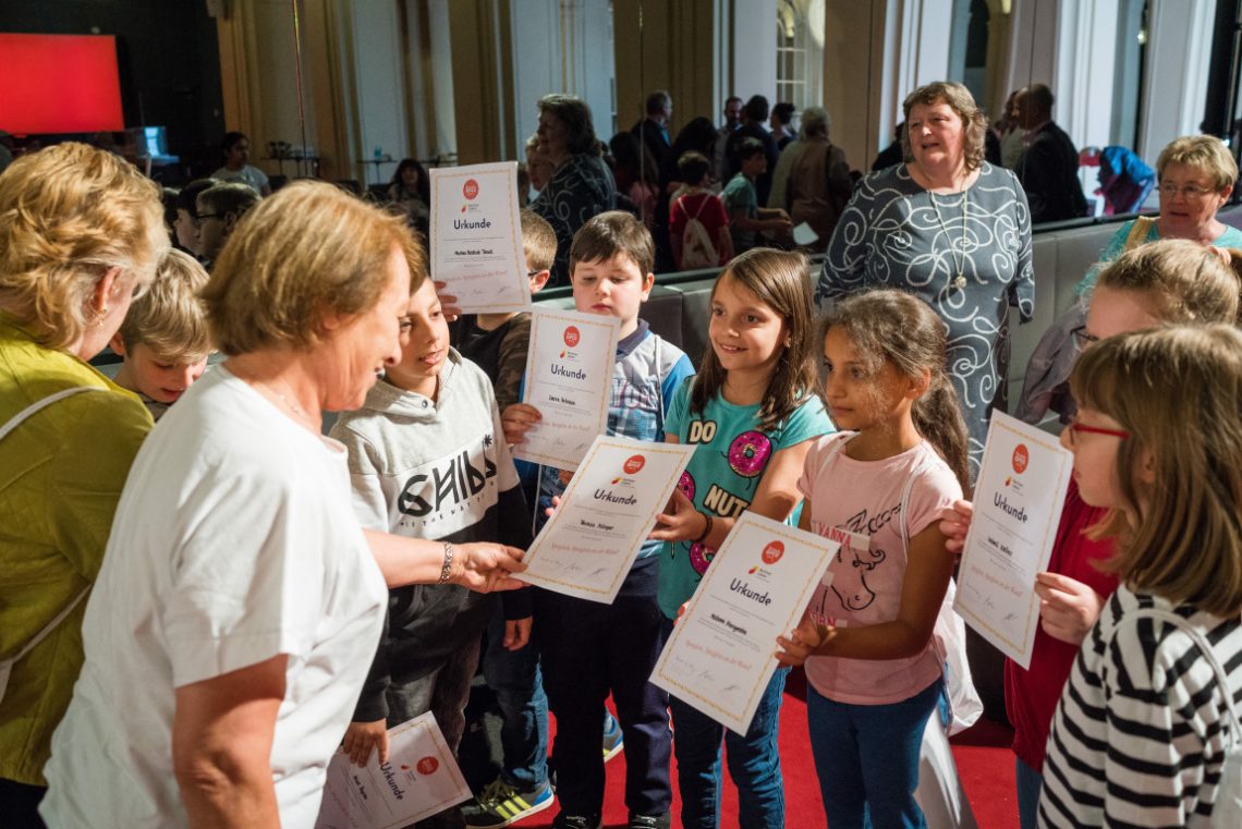 Kinder erhalten Urkunde beim Projekt Abenteuer Oper 77 Zwerge