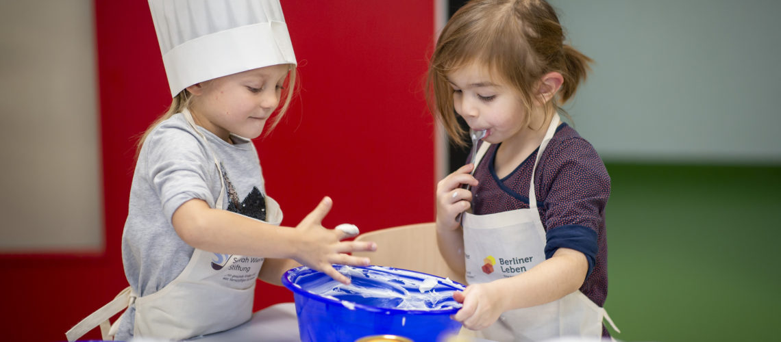 Backende Kinder mit Schürze der Stiftung Berliner Leben