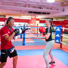 Trainer und Mädchen trainieren im Boxring bei Wir aktiv. Boxsport