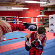 Jugendlicher geht im Boxring bei einem Schlag in Deckung