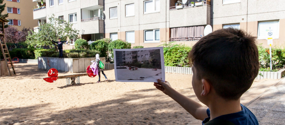 Junge auf einem Spielplatz betrachtet ein Foto