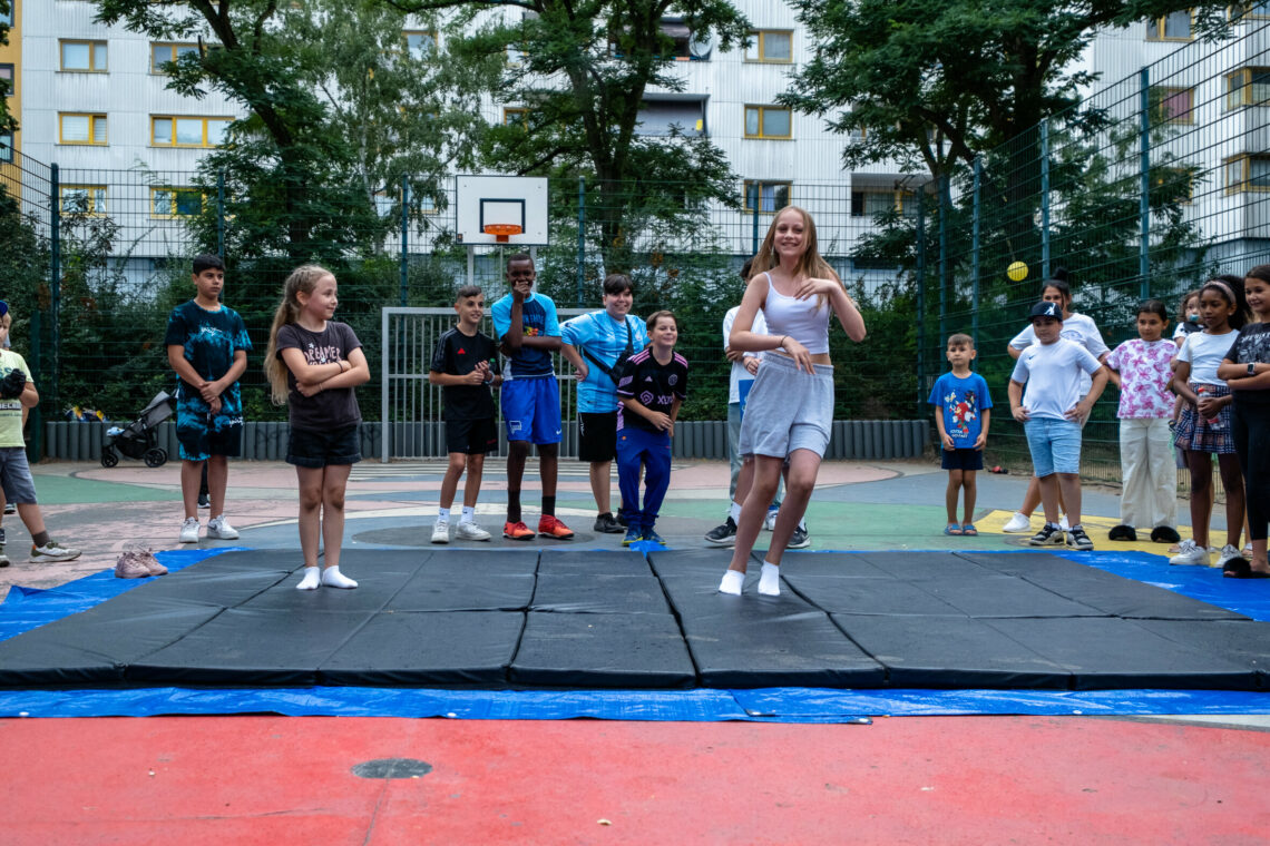 Kinder tanzen vor Publikum und werden dabei angefeuert